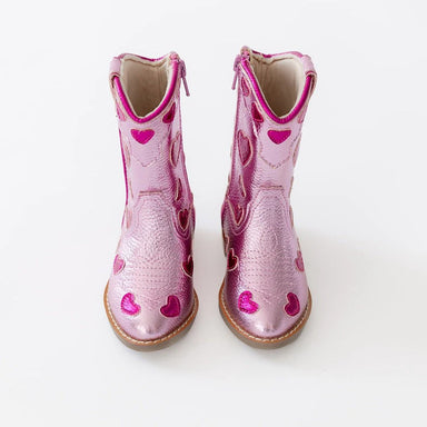 Pink cowboy boots with heart designs on a white background