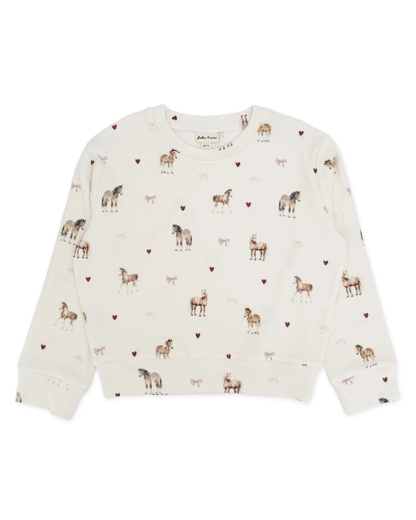 An ivory colored top with a horse and hearts print