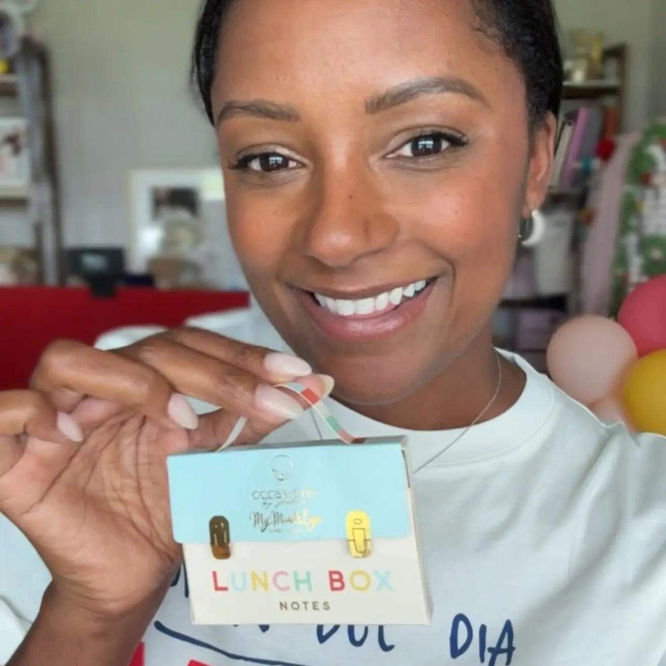 Person holding a product with 'Lunch Box Notes' packaging
