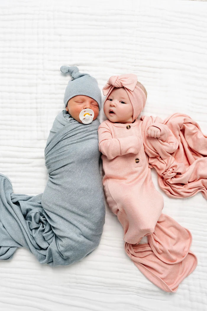 Two babies wrapped in baby blue and pink blankets