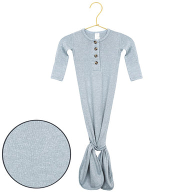 A light blue long-sleeve baby tummy henley dress with a buttoned neckline and a gathered bottom, hanging on a gold hanger against a white background, with a circular fabric detail inset in the lower left.