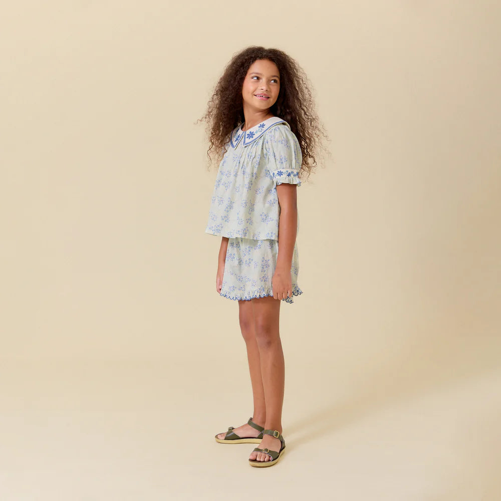 Young girl wearing a floral dress on a beige background