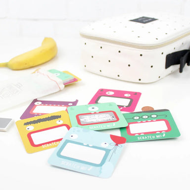 Colorful scratch-off labels with cartoon designs on a white surface.