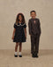 Girl wearing a black floral dress with a white lace collar and puff sleeves beside a boy in a brown suit Noralee Janette Dress Winter Ditsy