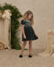 A green velvet dress featuring a smocked bodice, puff sleeves with lace trim, and a scalloped lace Peter Pan collar.
