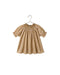 A toddler girl's short-sleeve dress with a smocked bodice and a small white floral print on a warm tan background, hanging on a metal hanger against a white background.