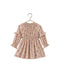 A long-sleeve girl's dress with a delicate pink and brown floral print, featuring a smocked waist and ruffled sleeves, hanging on a wooden hanger against a white background.
