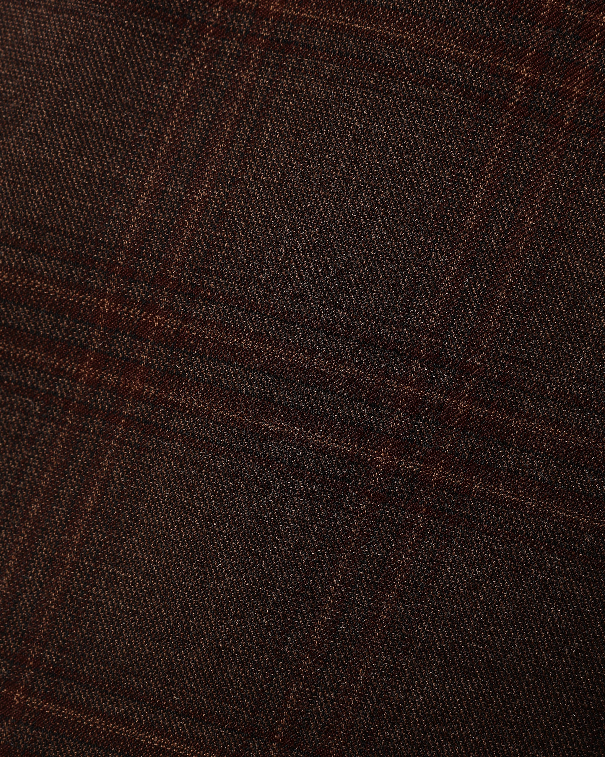 Close up of dark heathered plaid fabric in warm brown and black tones with a subtle woven texture for a boys garment