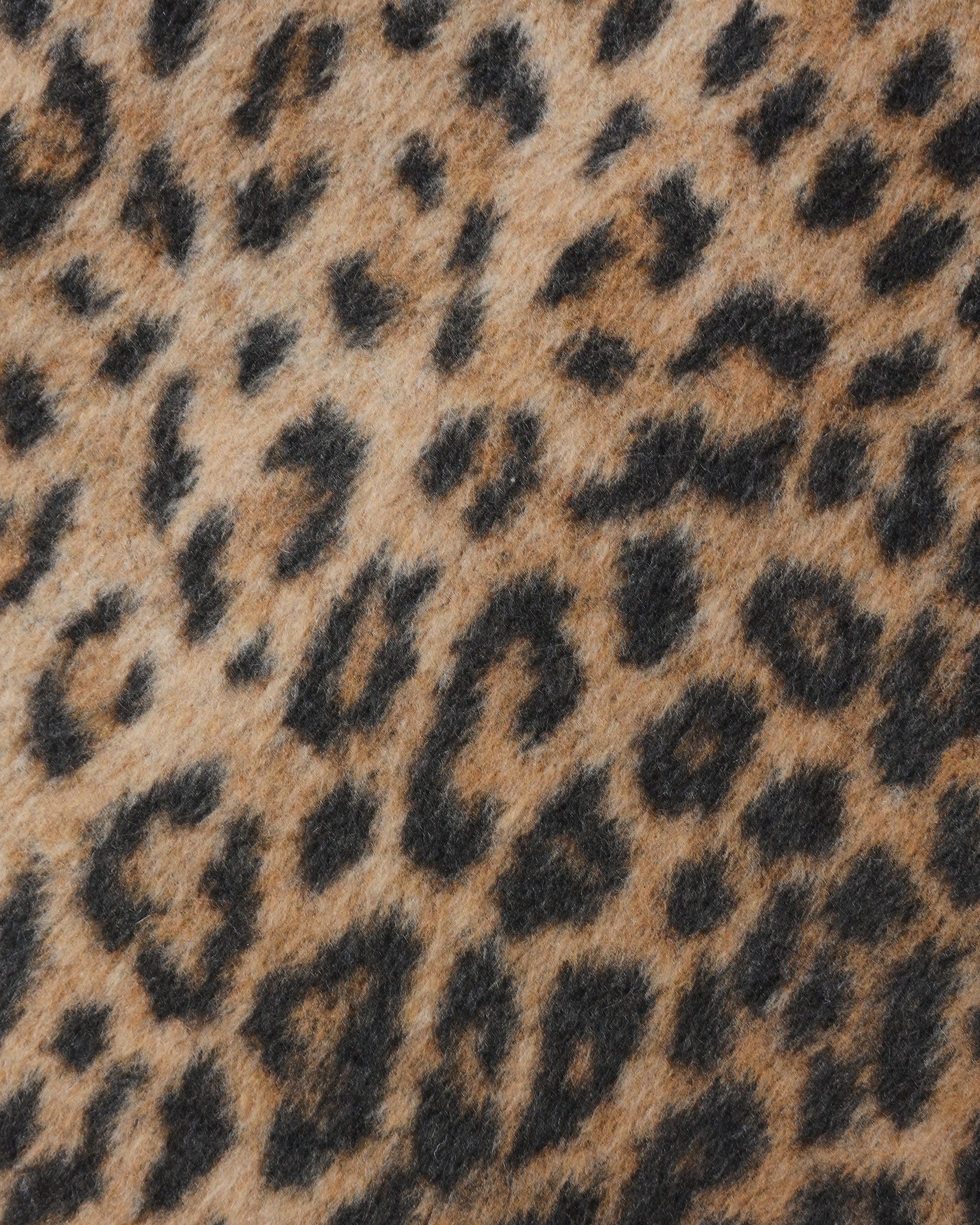 Close view of tan and black leopard print faux fur fabric from the Eloise coat by Noralee with a soft textured finish