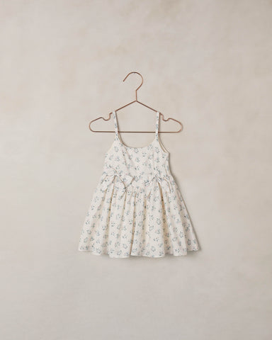 Floral dress on a hanger against a beige wall