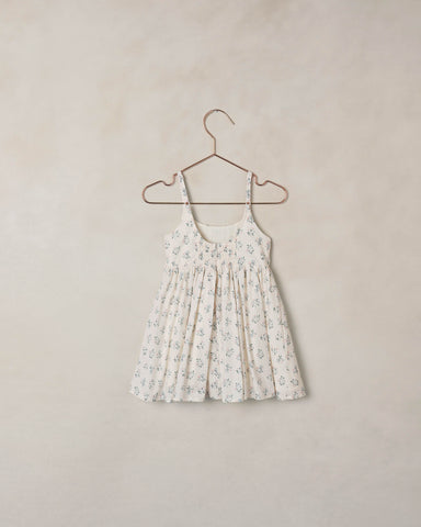 Floral dress on a hanger against a beige background