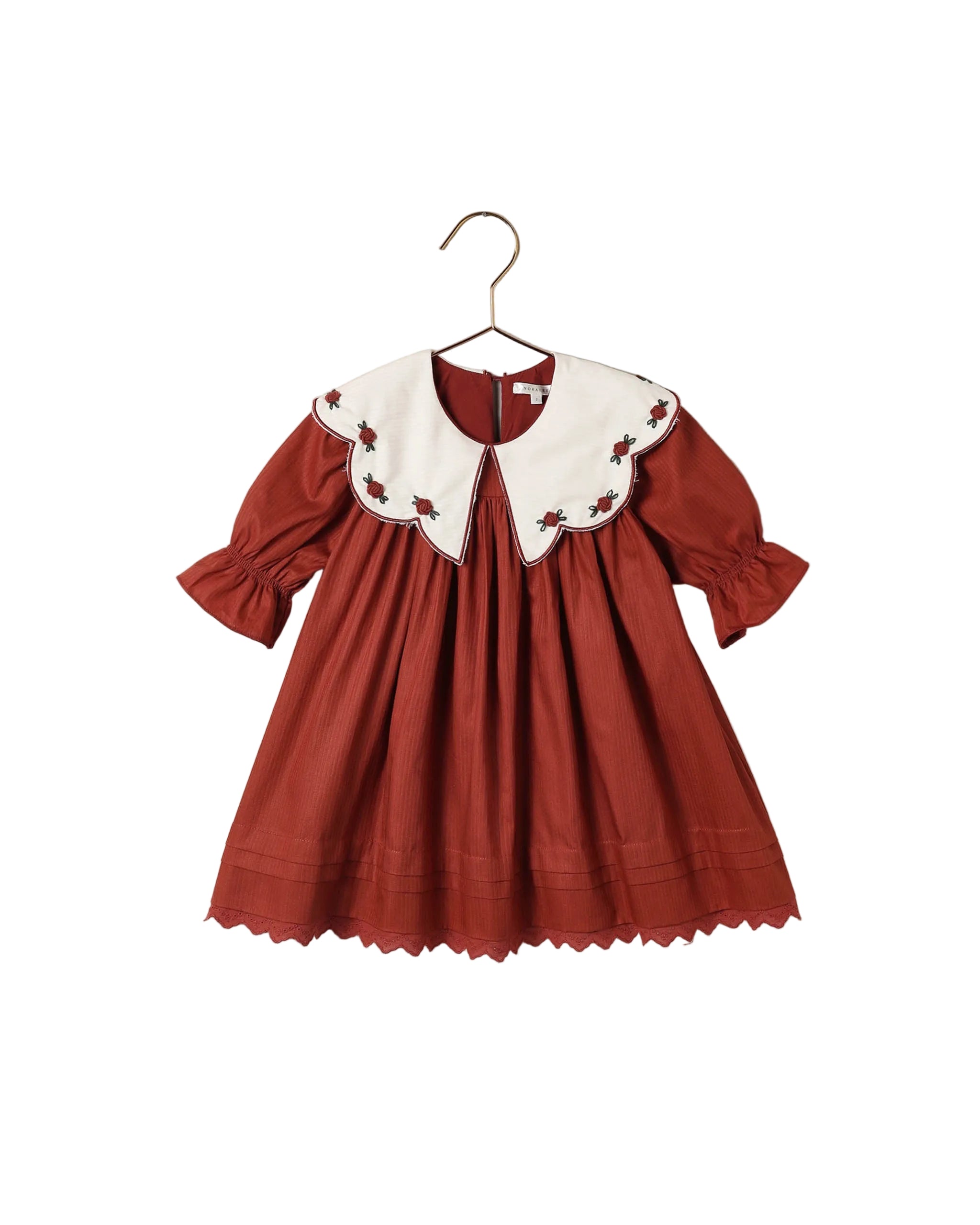 Noralee ruby red girls dress with a scalloped embroidered white collar long sleeves gathered skirt and scalloped hem displayed on a hanger