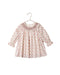 An ivory floral dress with a  delicate smocked collar and long sleeves with elastic cuffs to its full, gathered body. The back has a shell button placket at the back for easy changes.