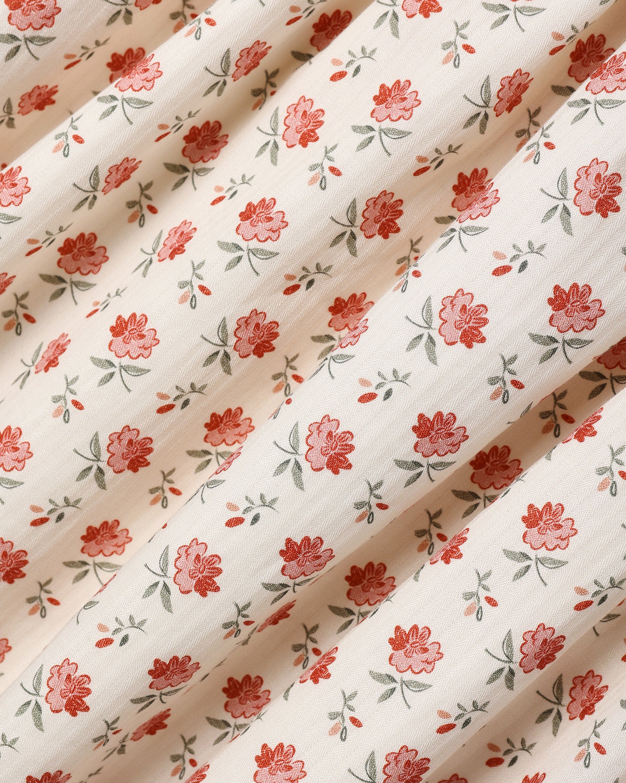 A close up of an ivory fabric with a floral pattern.