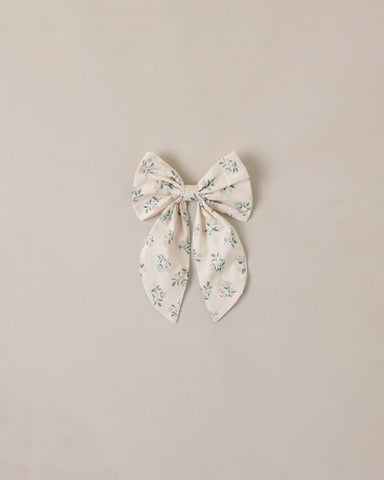 Floral-patterned bow on a beige background