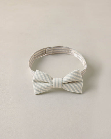 Striped bow tie and headband set on a beige background