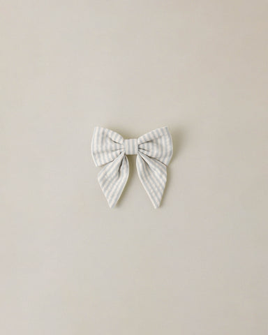 Striped bow hair accessory on a beige background