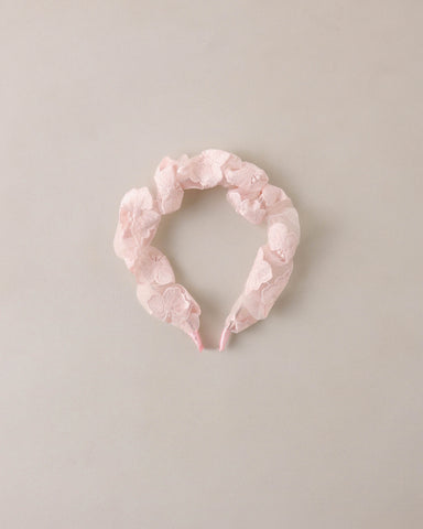 Pink floral headband on a light beige background