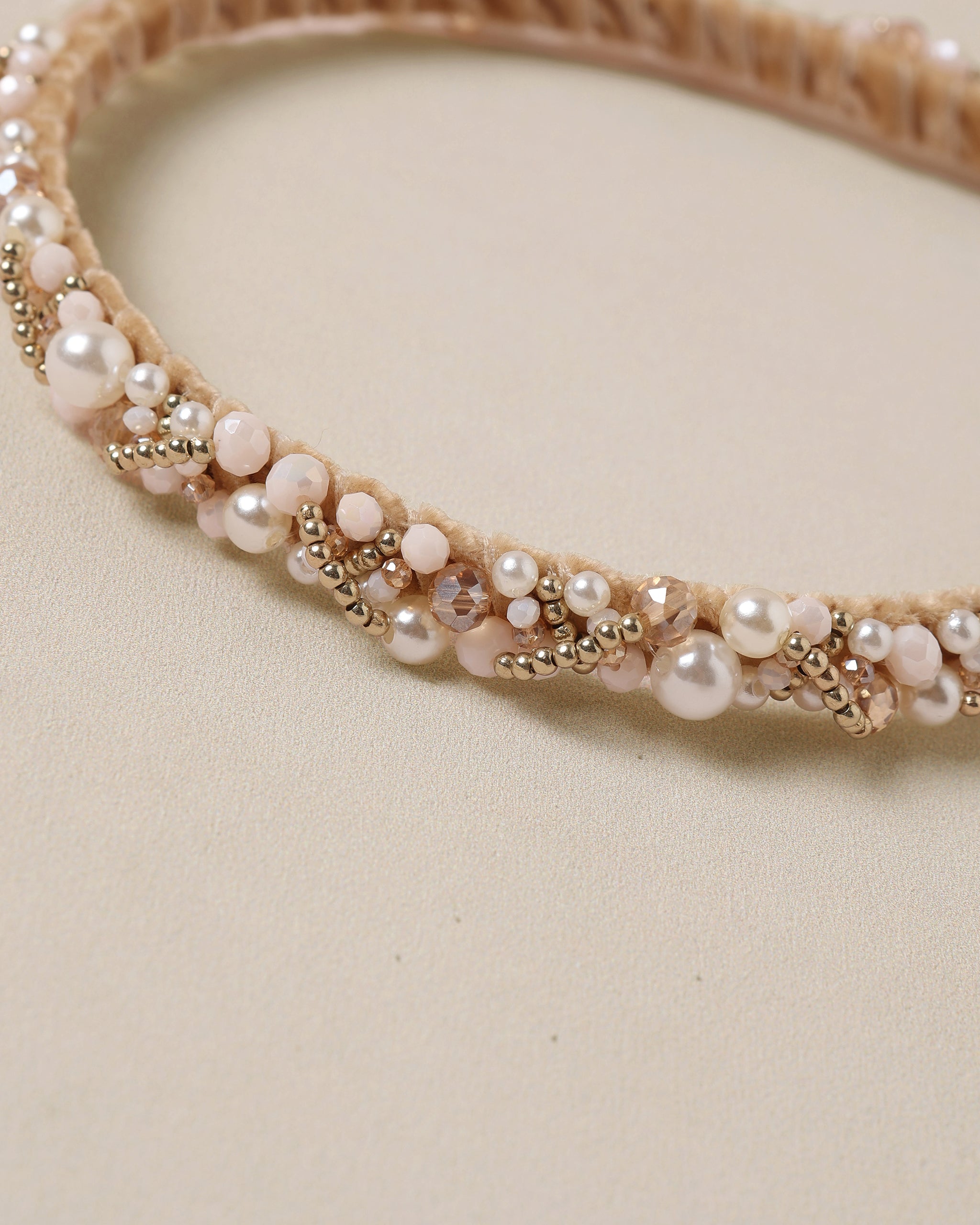 Beaded headband with pearls on a beige background