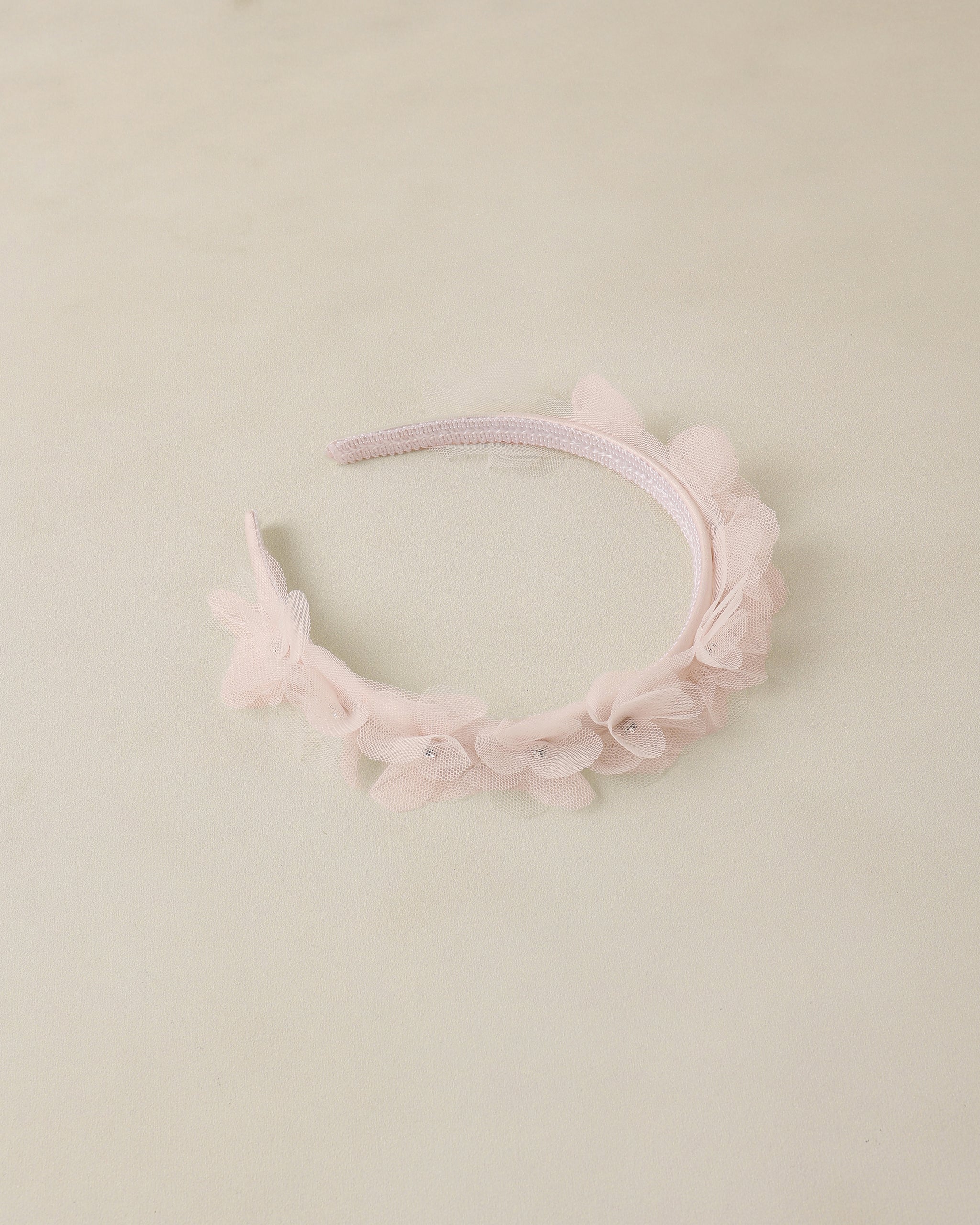 Pink floral headband on a light beige background