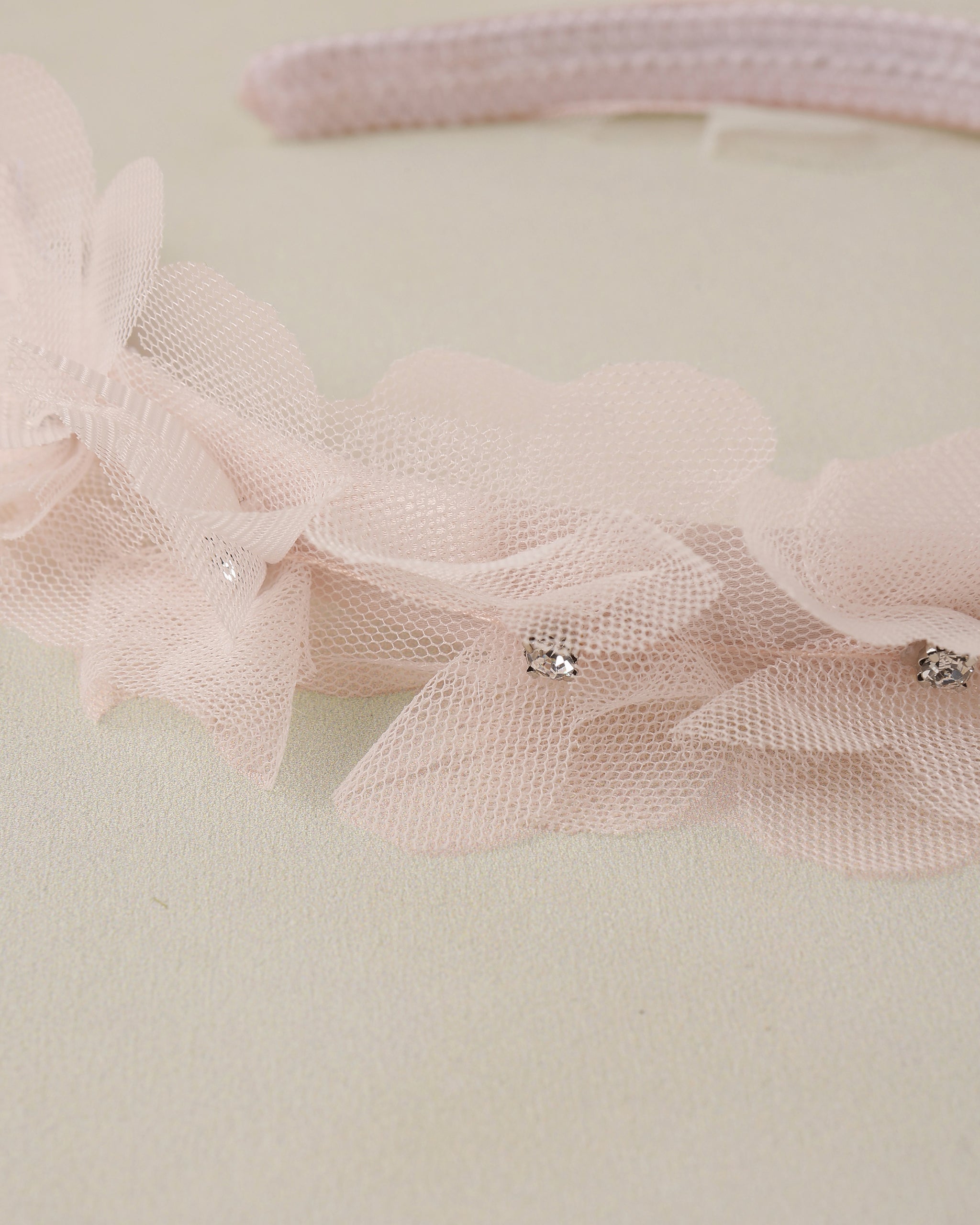 Pink headband with tulle and rhinestone details on a light background