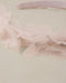 Pink headband with tulle and rhinestone details on a light background