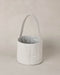 Textured blue and white basket with handle on a beige background