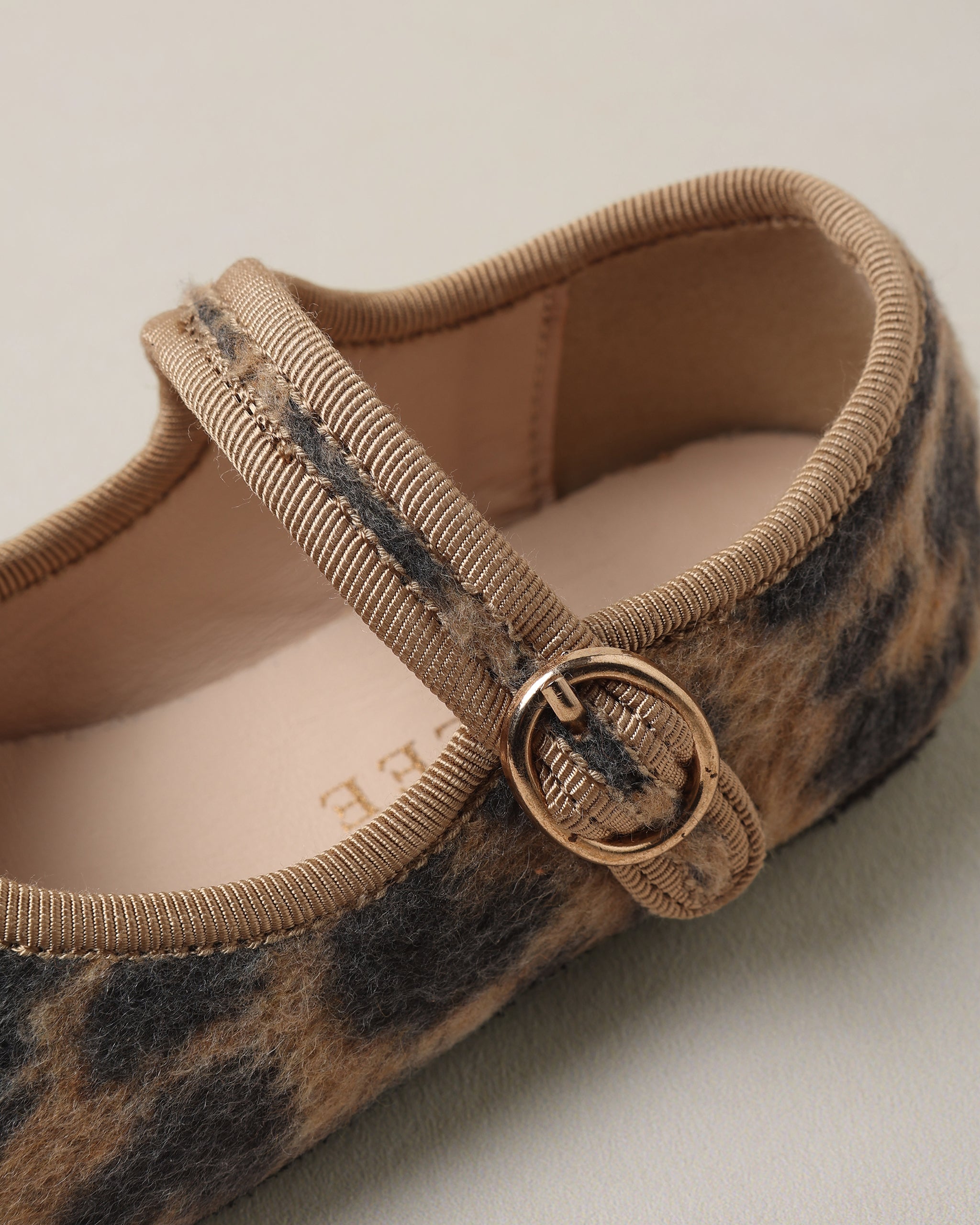 Close up of a Noralee girls leopard print ballet flat with a square toe and adjustable ankle strap secured by a brass buckle