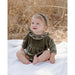 baby girl sitting up wearing pine green colored long sleeve velvet bubble with ruffle detail at the neck and gathered waistline