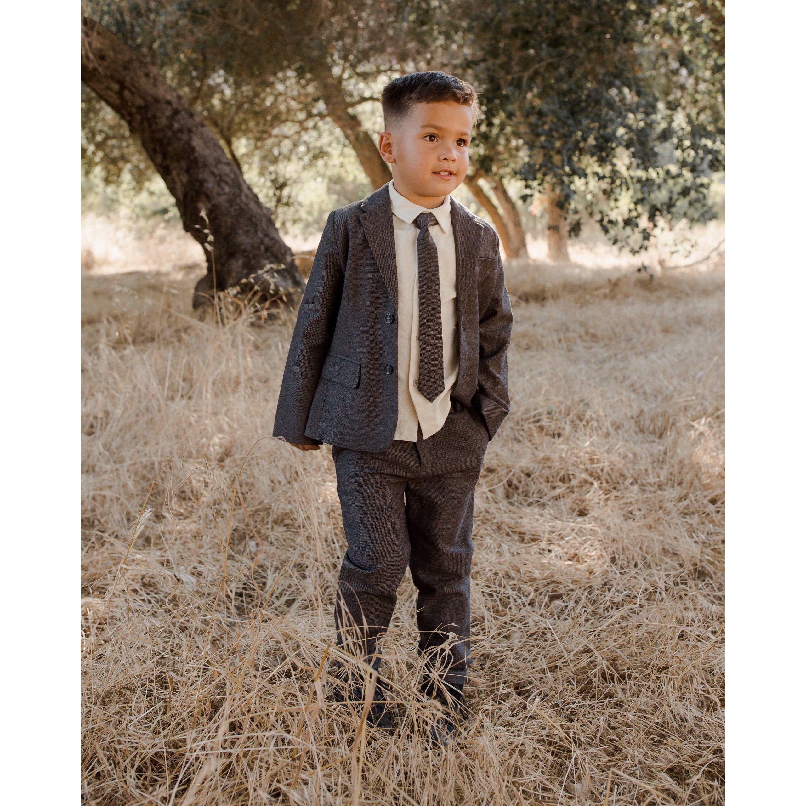 boy wearing charcoal black blazer with matching pants and skinny tie