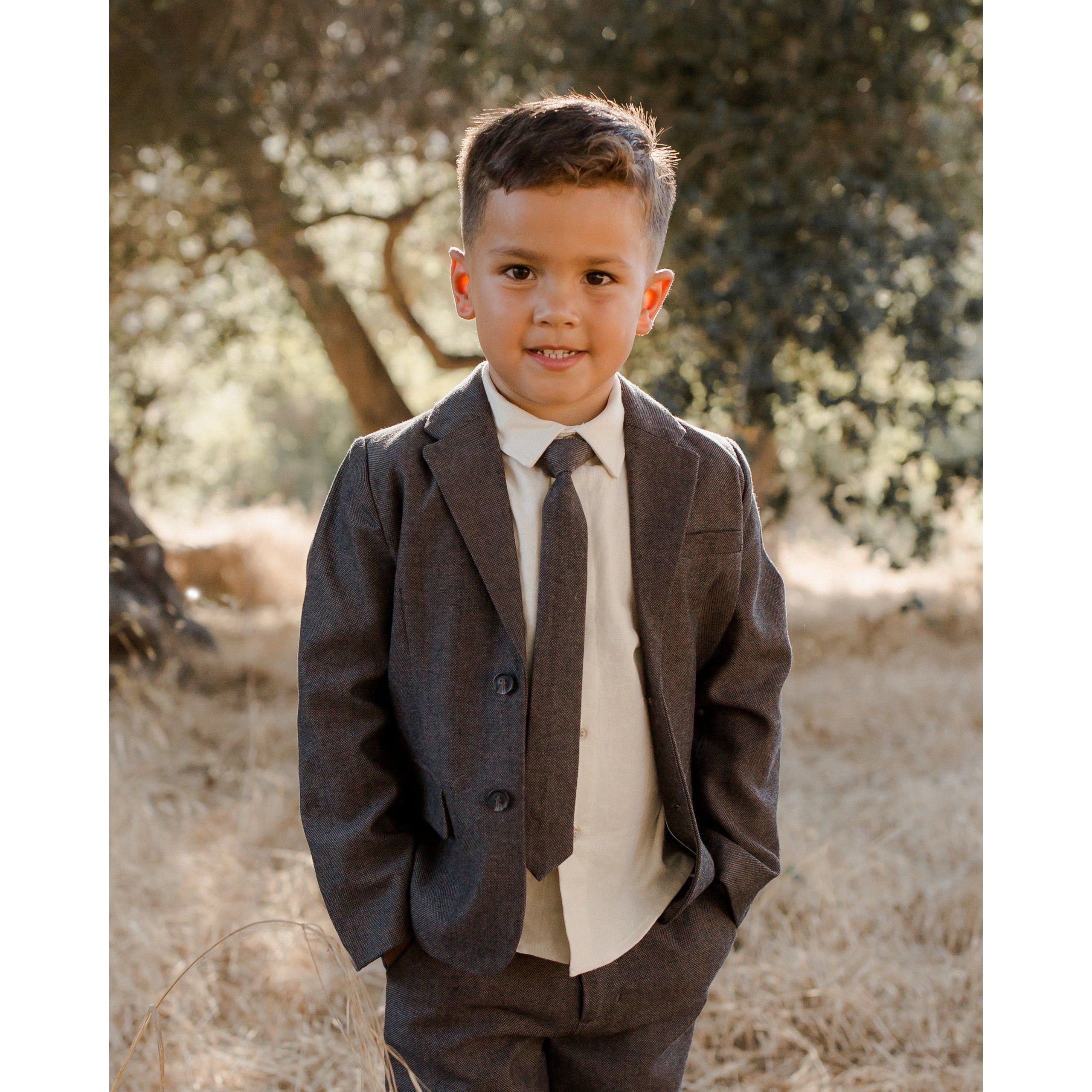 boy wearing charcoal black blazer with matching pants and skinny tie