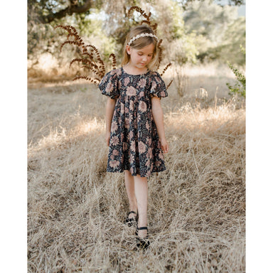 girl wearing black puff sleeve dress with holiday bloom floral blush print