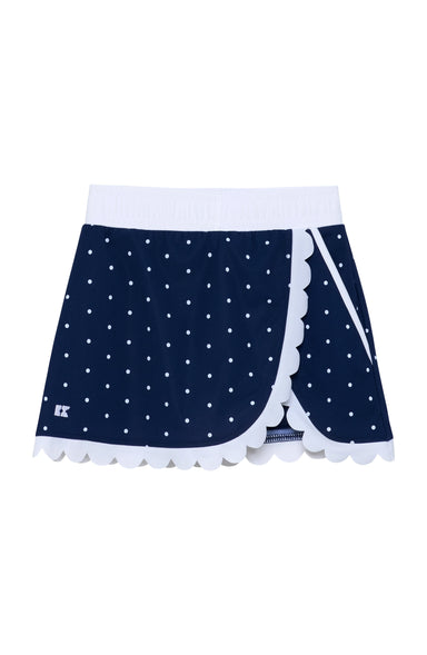 A navy blue wrap-style skort with white polka dots, a white waistband, and white scalloped trim along the front edges, shown on a plain white background.