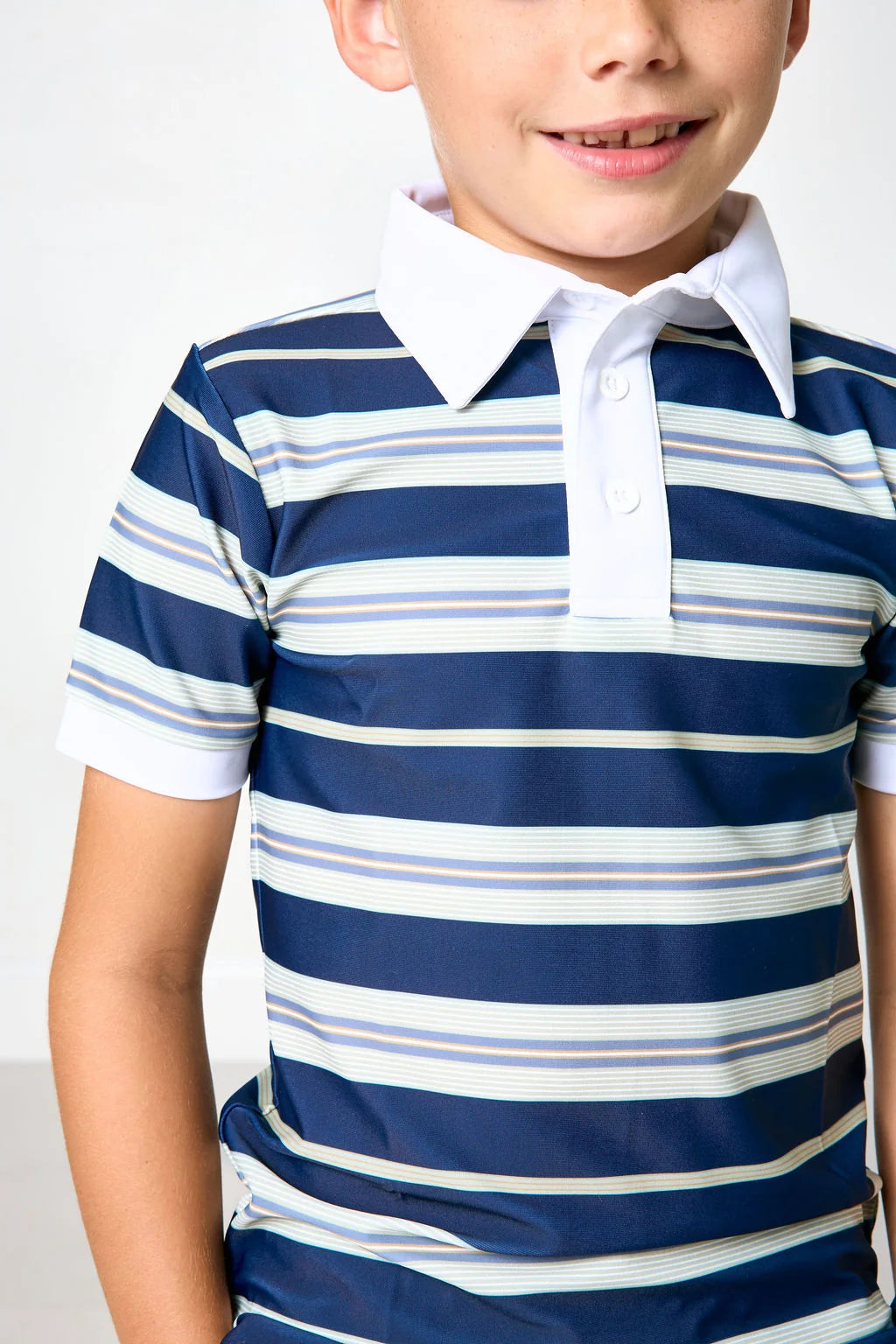 A close-up of a child wearing a short-sleeve polo shirt with horizontal navy, white, and light blue stripes, featuring a solid white collar and placket.