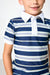 A close-up of a child wearing a short-sleeve polo shirt with horizontal navy, white, and light blue stripes, featuring a solid white collar and placket.