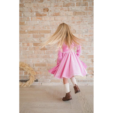 girl twirling in long sleeve baby pink velvet twirl dress
