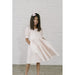 girl wearing light pink and white striped puff sleeve dress with pockets