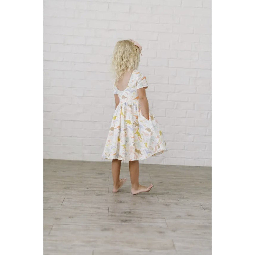 girl wearing dainty dinosaur printed twirl dress with pockets