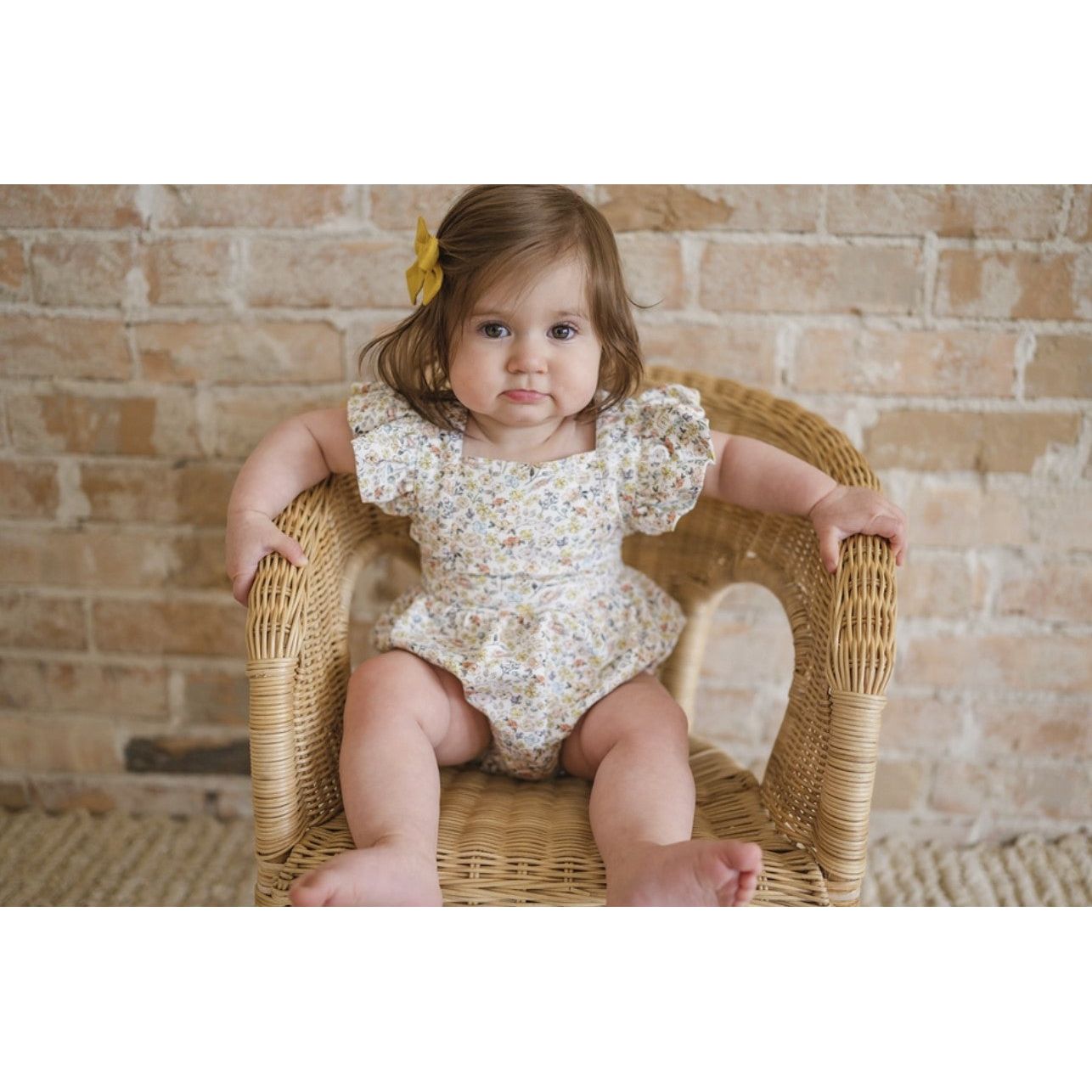 baby girl wearing white ruffle sleeve bubble with floral print