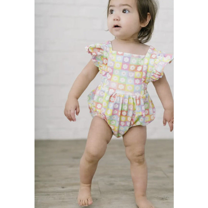toddler wearing multicolor floral bubble romper with flutter sleeves