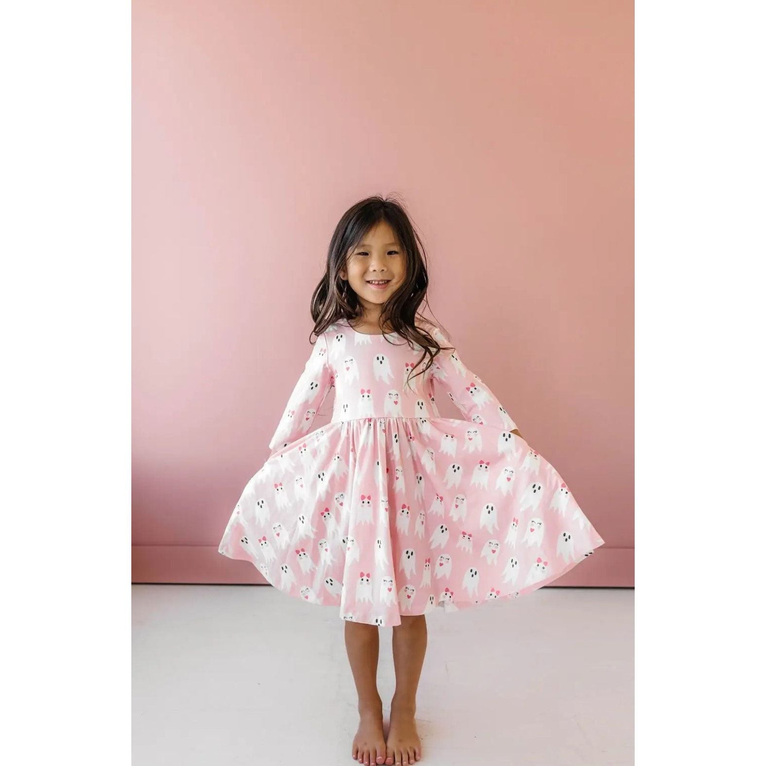 girl wearing 3/4 length sleeve pink dress with girly ghost print