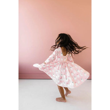 girl twirling while wearing 3/4 length sleeve pink dress with girly ghost print