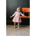 toddler girl wearing 3/4 length sleeve pink dress with girly ghost print