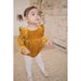 toddler girl wearing golden yellow velvet long sleeve bubble romper with ruffle detail in front and back