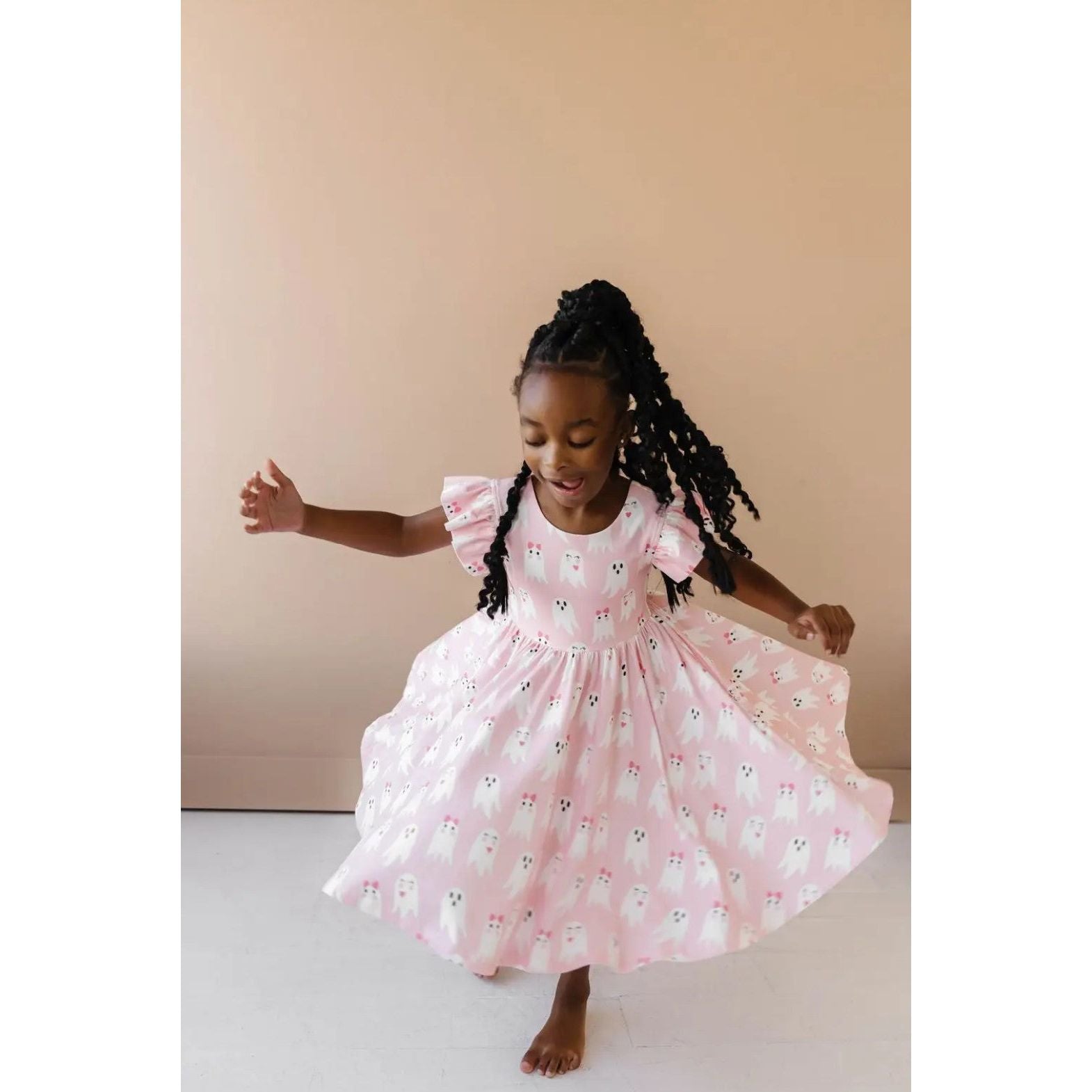 girl wearing pink ruffle short sleeved dress with girly ghost print