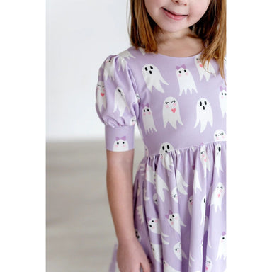 up close of girl wearing purple puff short sleeved dress with girly ghost print