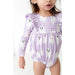 close up view of toddler girl wearing purple ruffle long sleeved bubble romper with girly ghost print