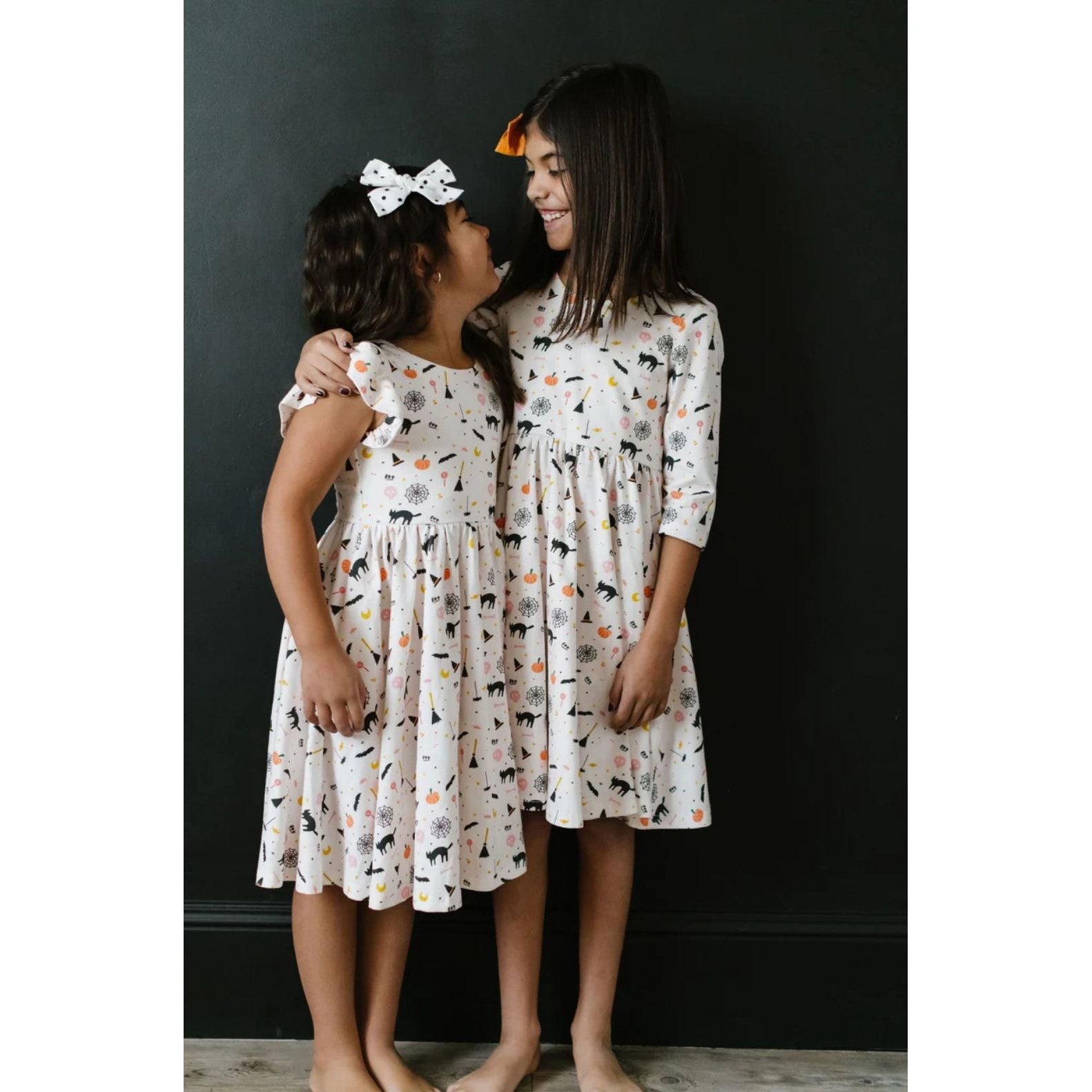 girls wearing white twirl dresses in spooky scenes print