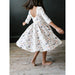 girl twirling in white 3/4 length sleeve dress with spooky scenes dress with scoop back
