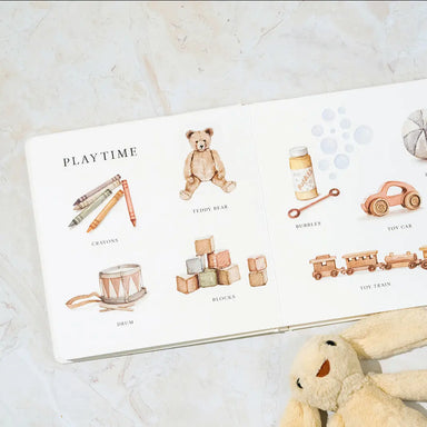 Children's book with illustrations of toys on a marble surface